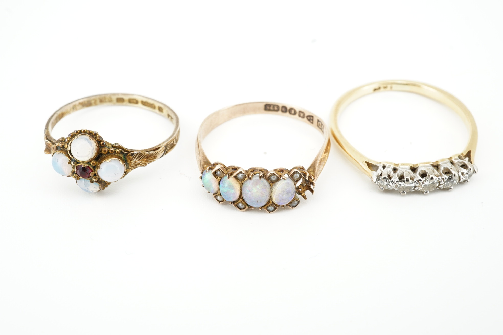 An early 20th century 9ct gold and opal cluster cluster set ring, size M, a 9ct and four(ex five) stone set opal half hoop ring and an 18ct and five stone diamond set half hoop ring. Condition - poor to fair